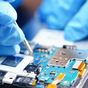 Person with latex gloves working on mobile circuitboard